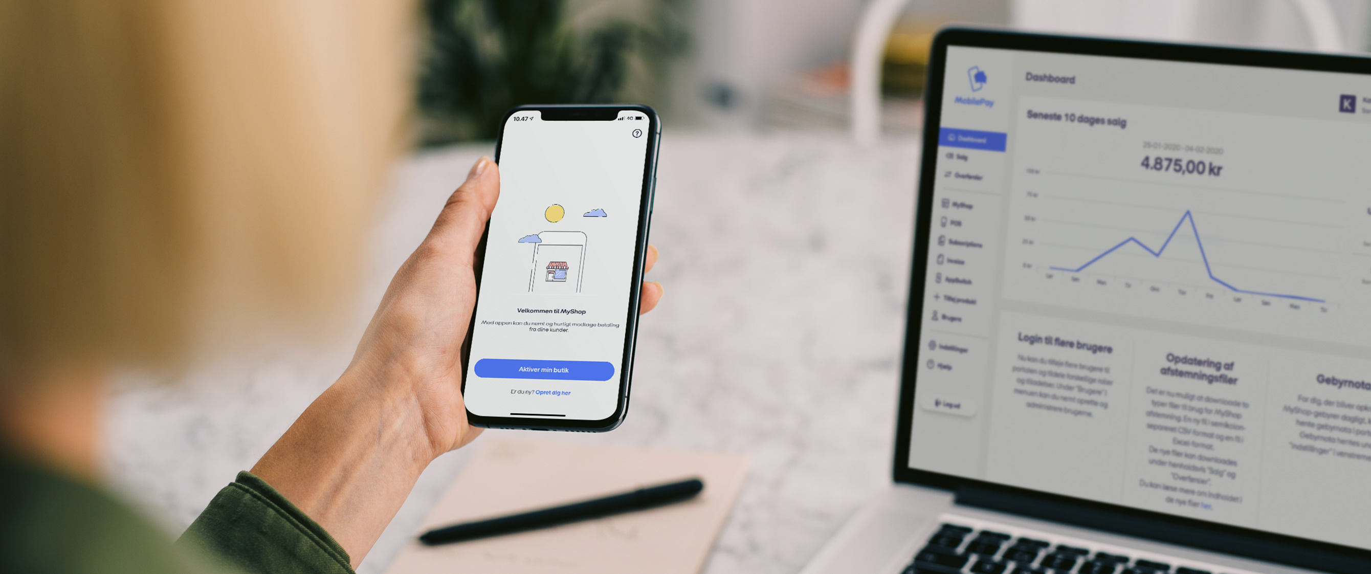 Billede af kvinde, der sidder med sin telefon og computer. På telefonen er hun inde i MyShop-appen og på computeren vises der et overblik inde fra MobilePay-portalen.