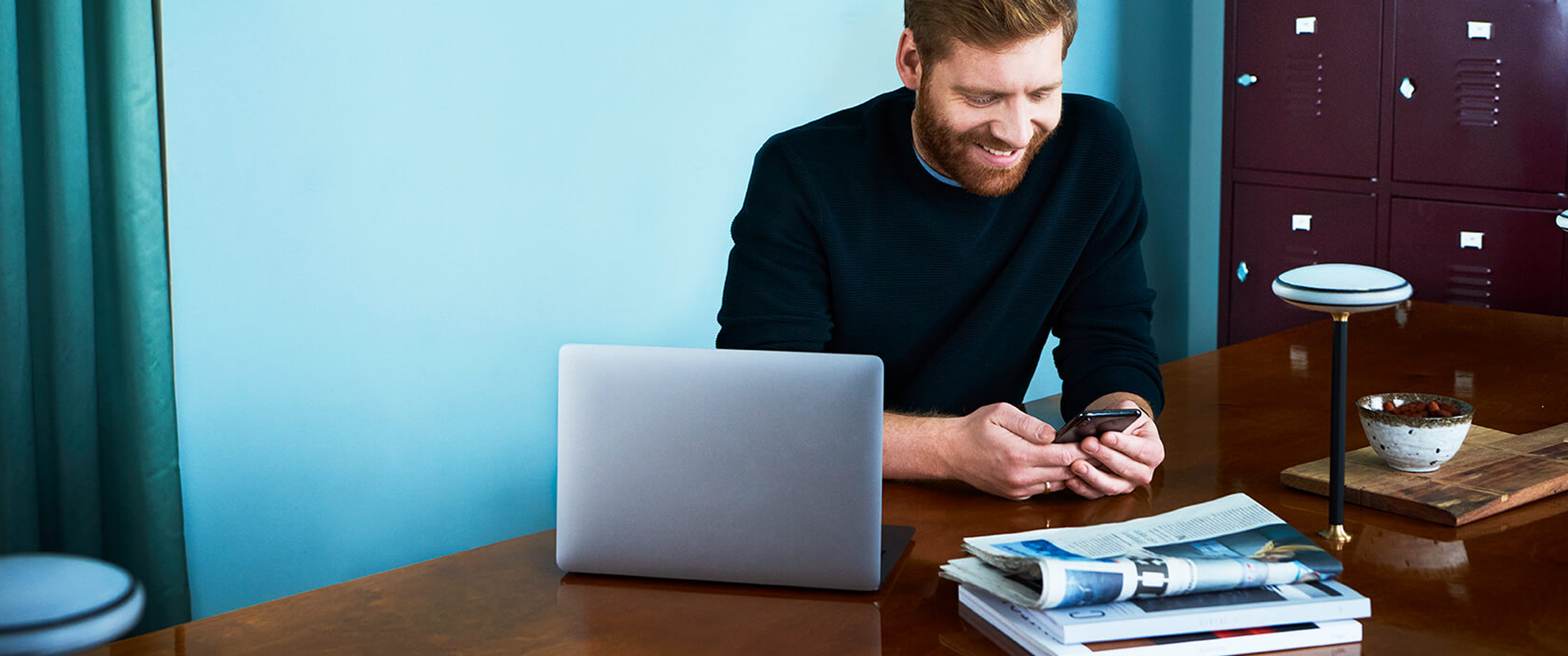 Man on office looking at his mobile phone.