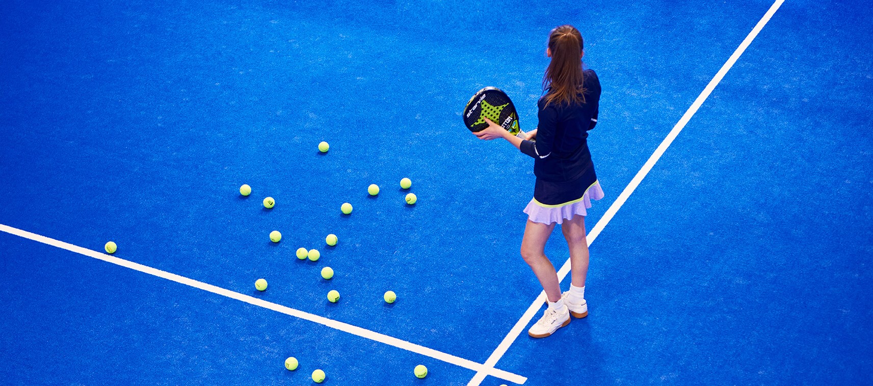 Girl on a blue tennis field.